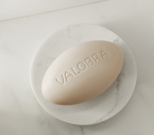 A bar of Valobra Soap in a round soap dish.