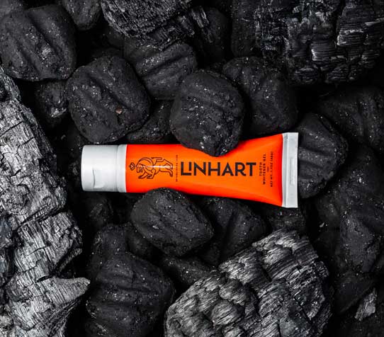 A tube of Linhart Toothpaste on coals.