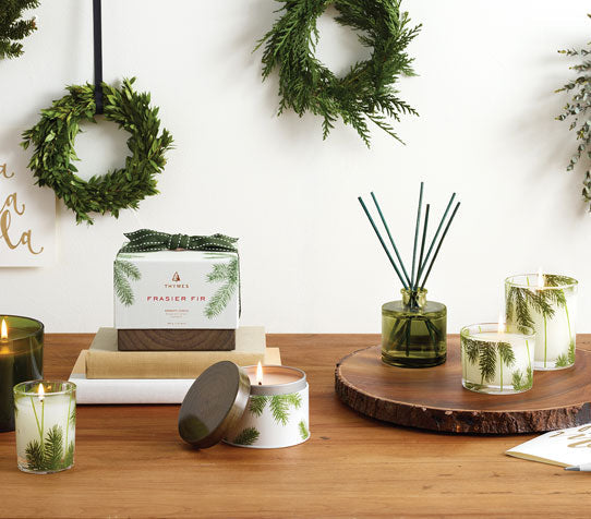 Several Frasier Fir Scented products in a holiday setting of holiday wreathes 