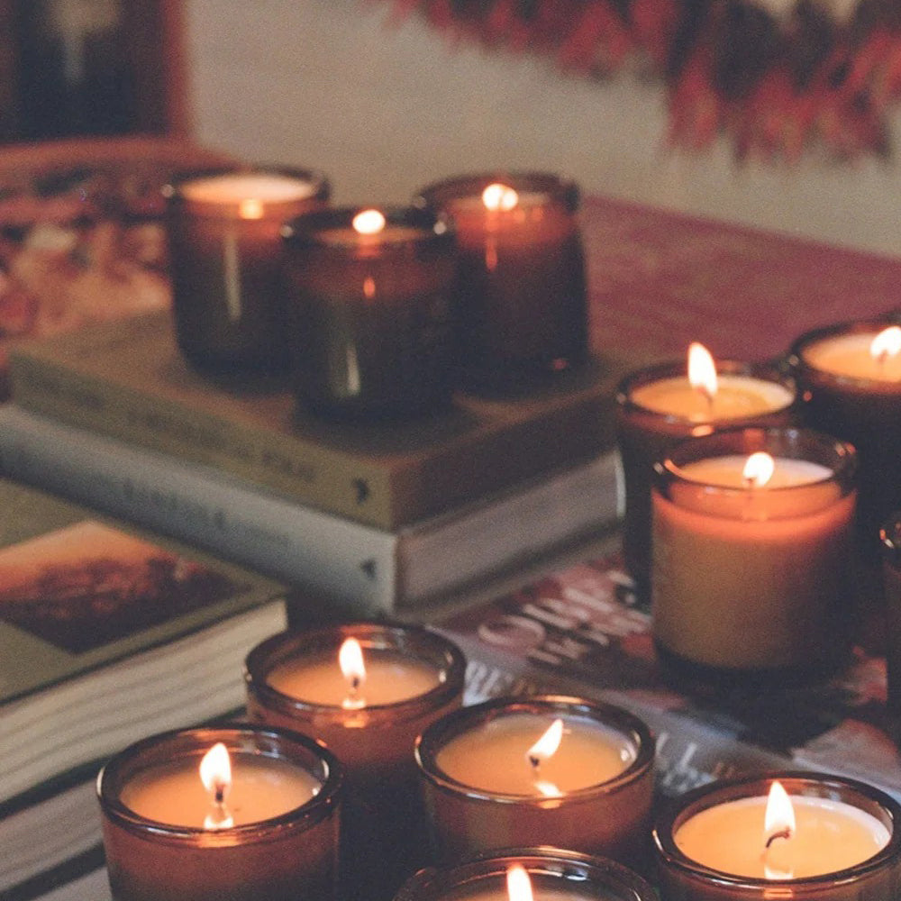 Candles in glass holders on a stack of books with a blurred background
