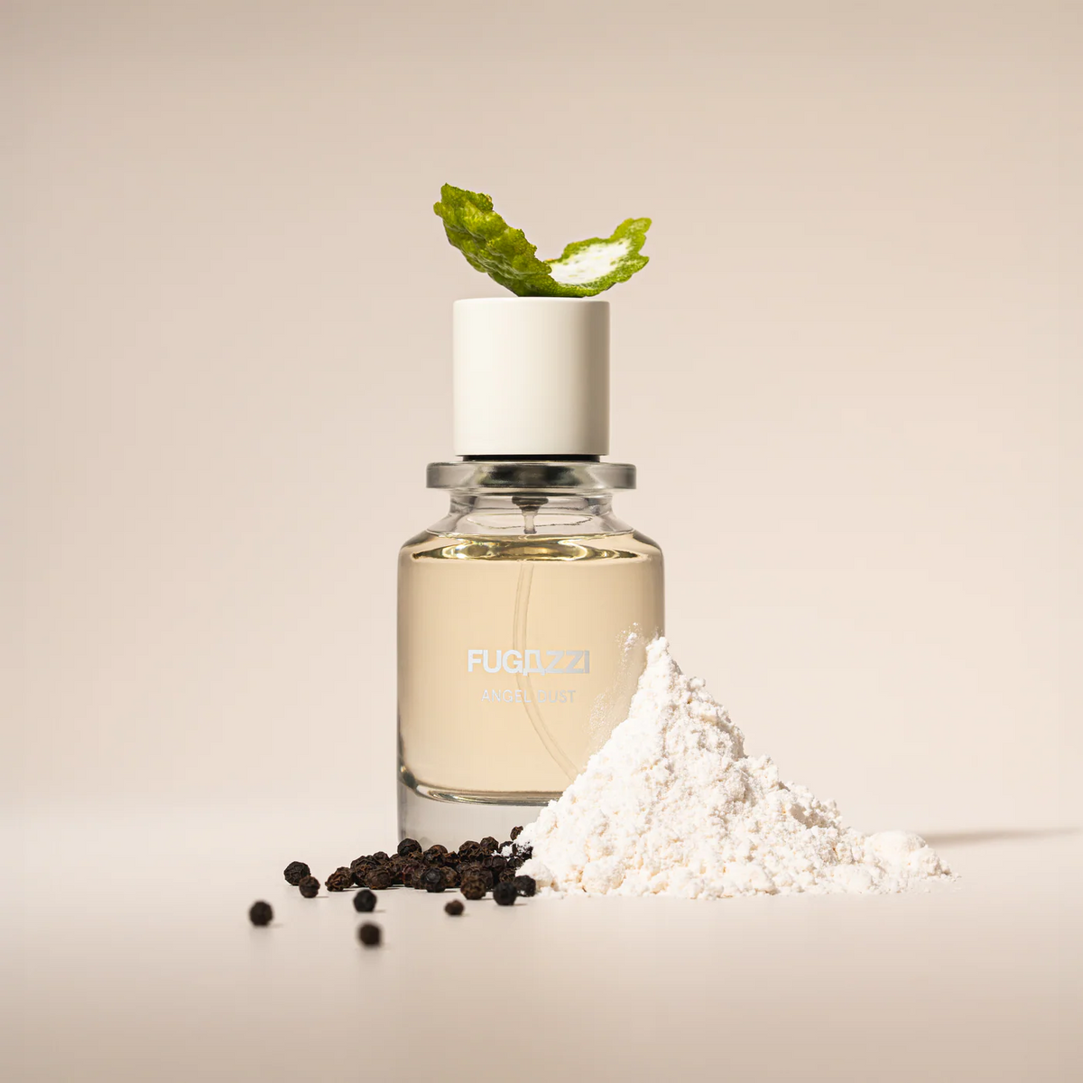 fugazzi angel dust perfume bottle with adornments around it representing the scents (lime, peppercorn, powder)