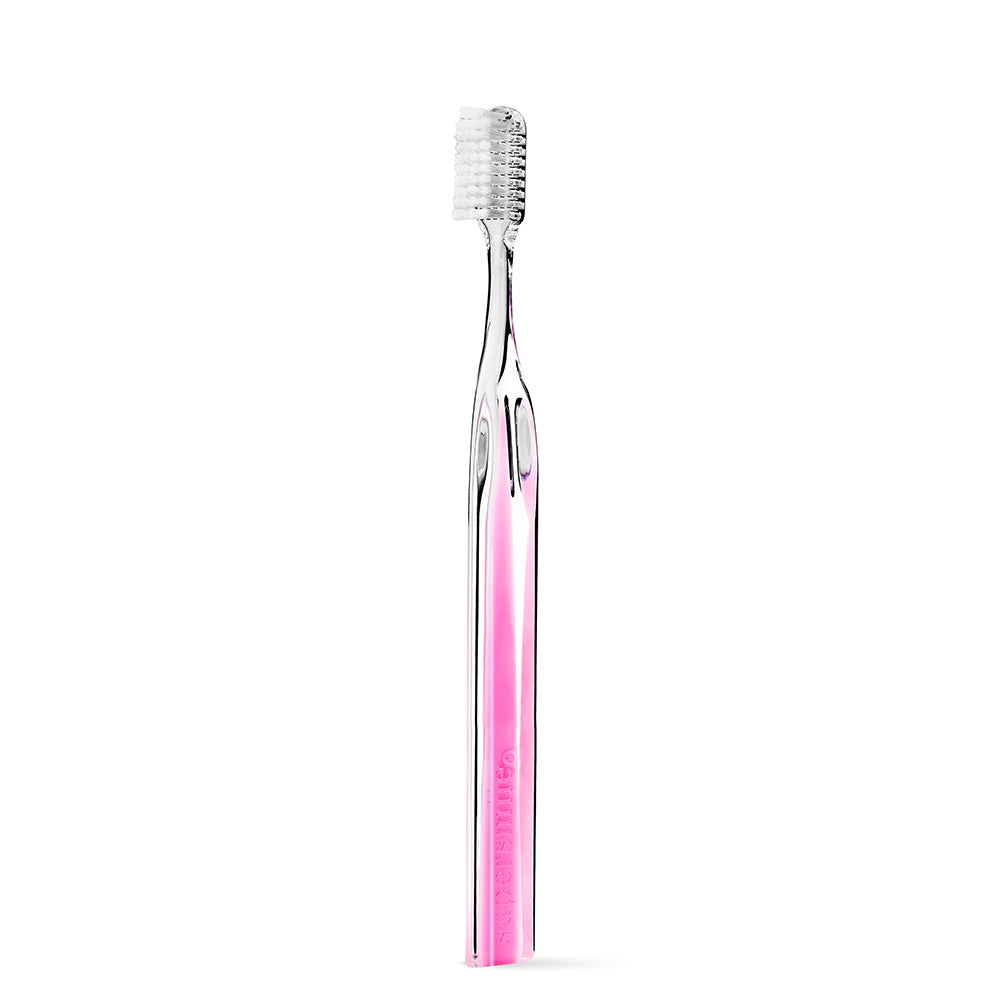 Clear Supersmile toothbrush with pink handle on a white background