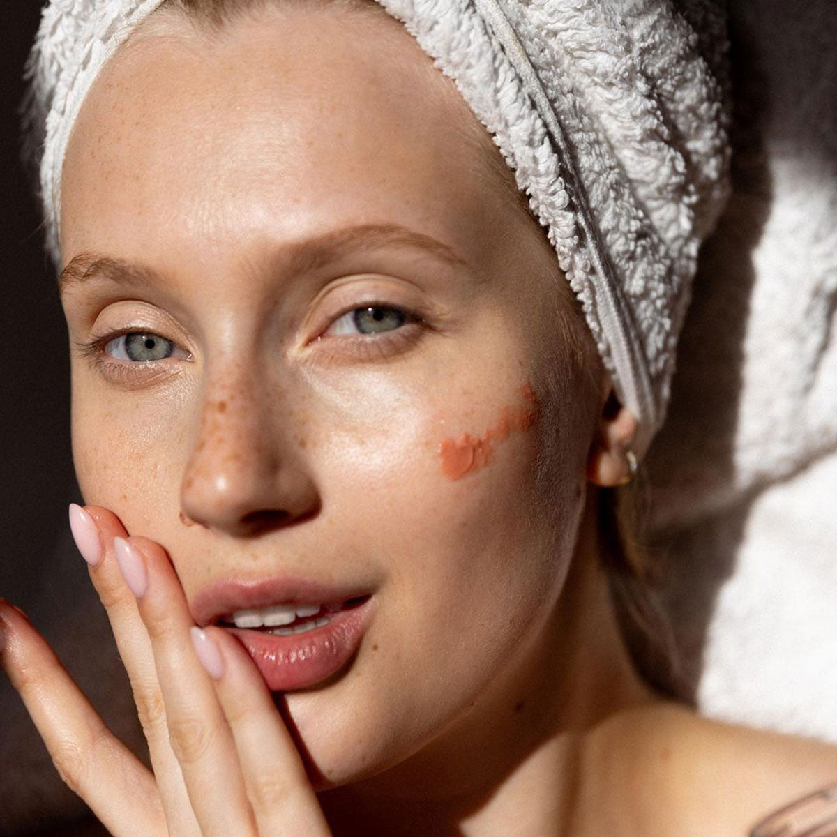 Person applying Embryolisse Radiant Complexion Cream in Rose Glow.