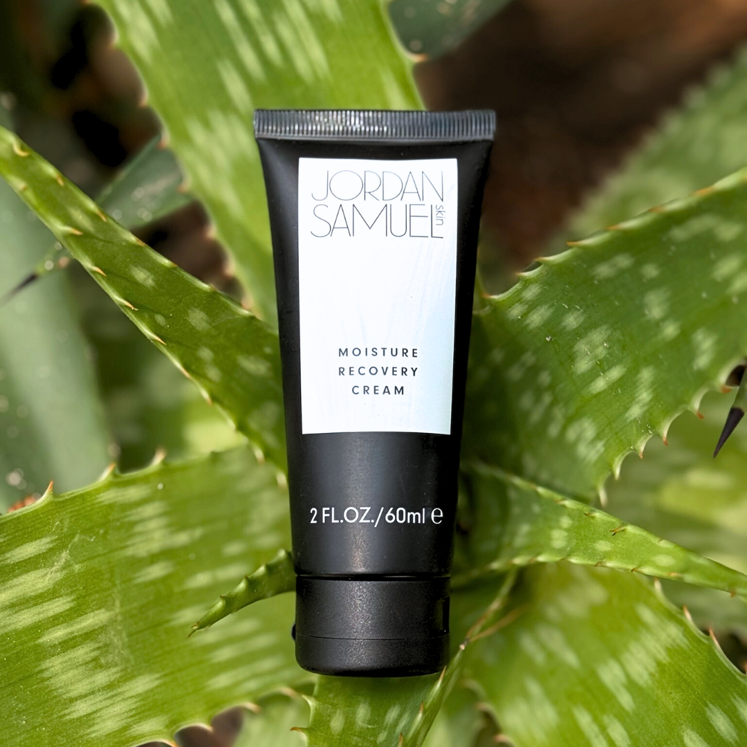 Black tube of Jordan Samuele Moisture Recovery Cream on a green leaf background