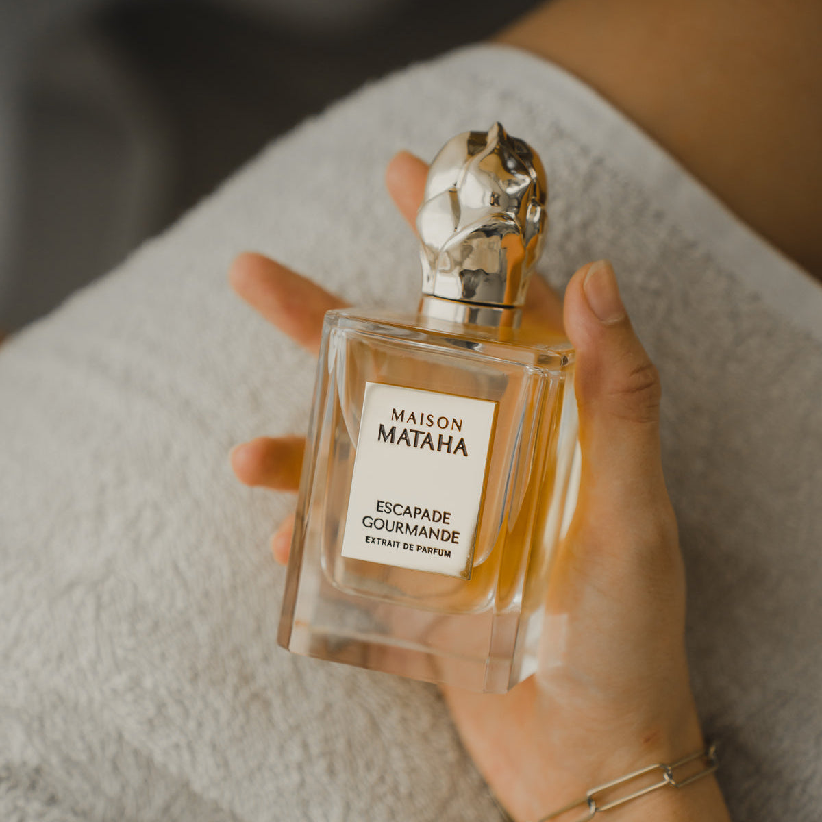 Hand holding a bottle of perfume