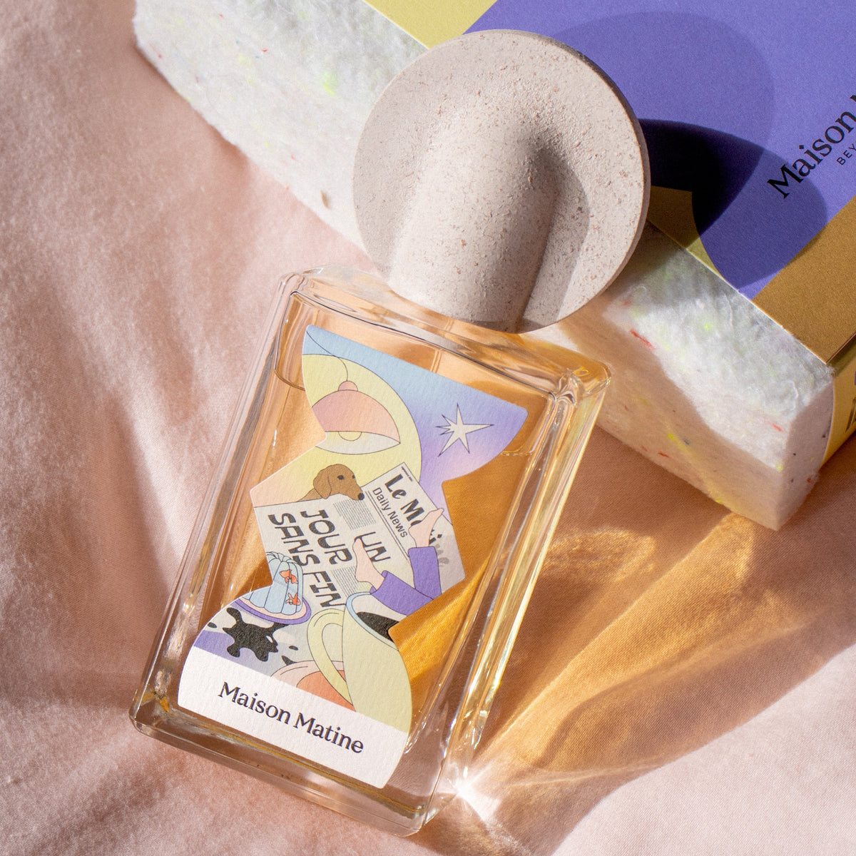 Perfume bottle with colorful label on a textured surface