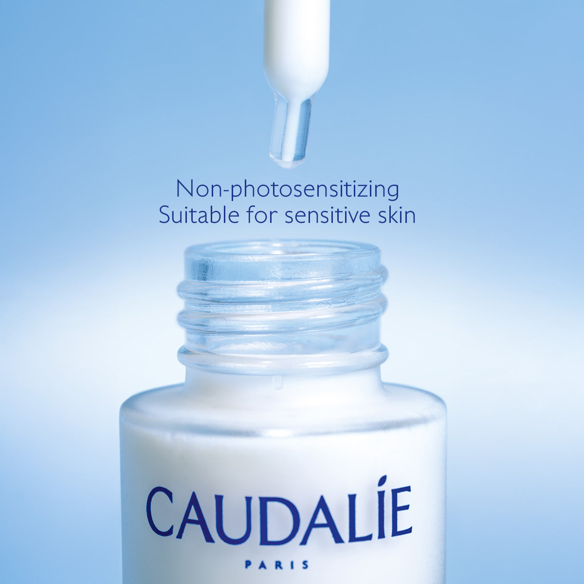 Caudálie bottle with dropper on a blue background