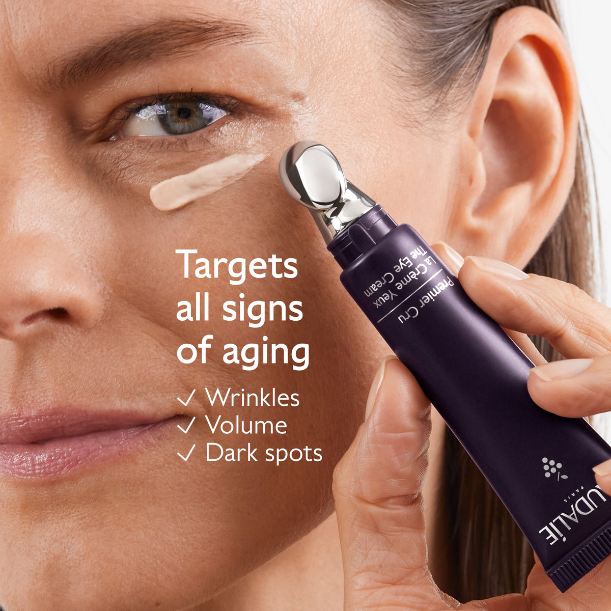 Woman applying a skincare product to her face with text highlighting its anti-aging benefits.
