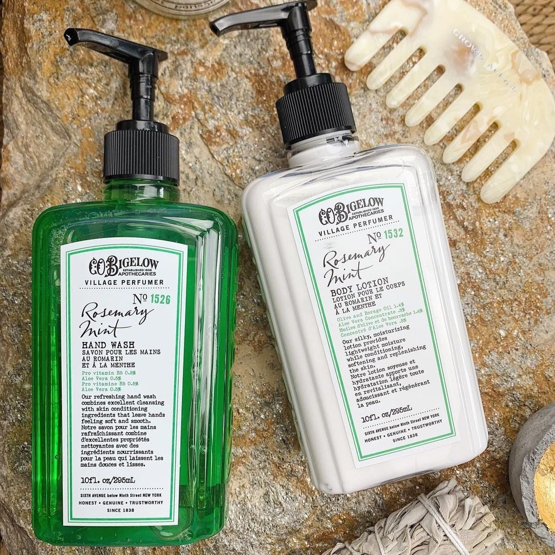 C.O. Bigelow Rosemary Mint Body Lotion 1532 and Rosemary Mint Hand Wash 1526 on stone surface next to hair comb and bundle of sage.
