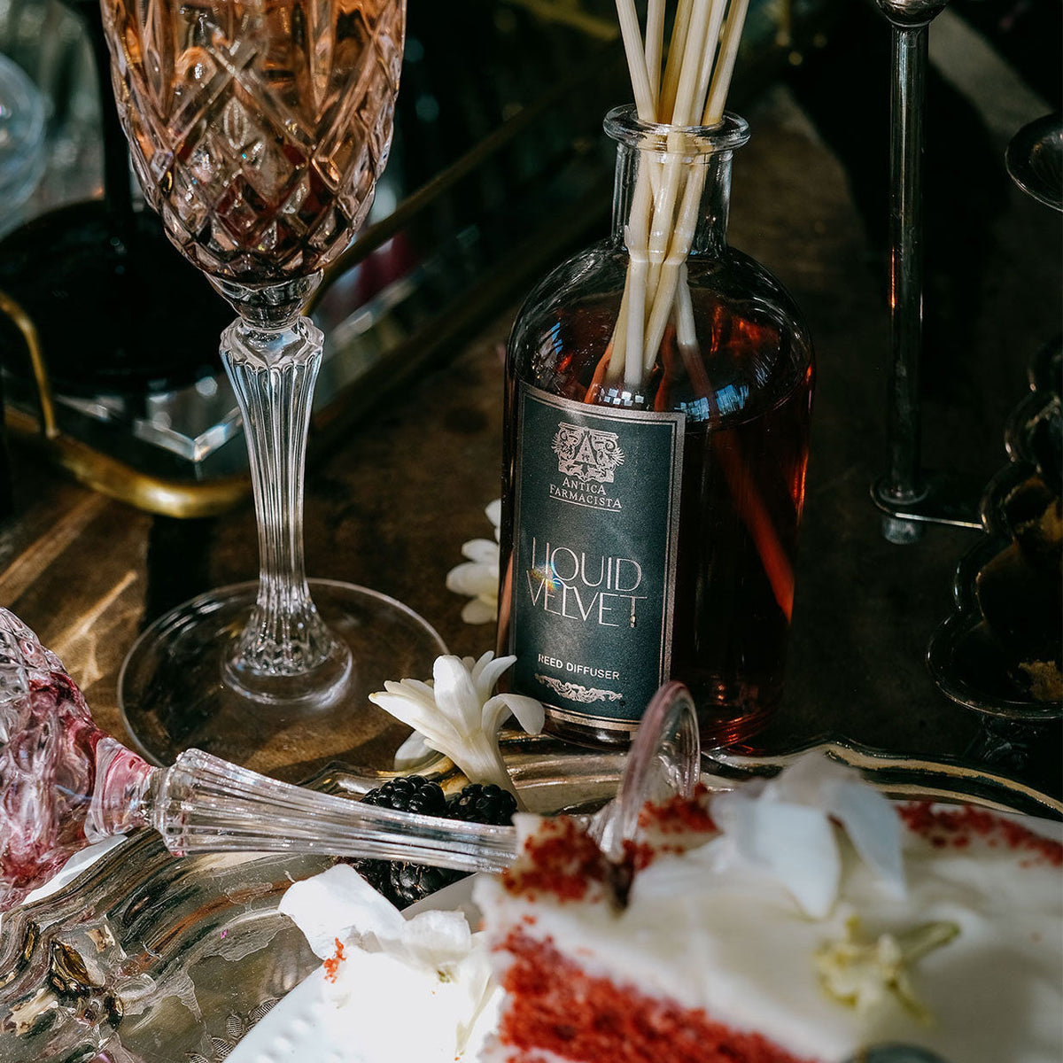 Liquid Velvet diffuser on a table with glasses and flowers