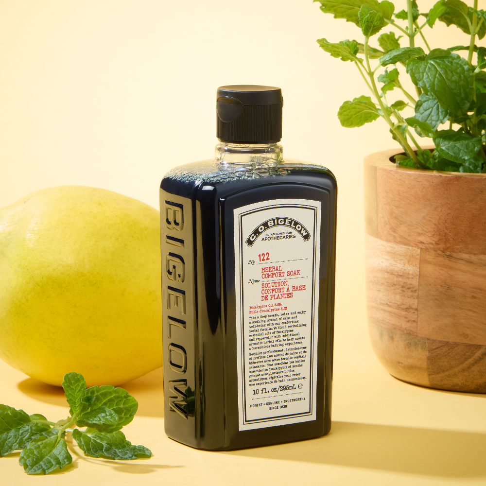 CO Bigelow Herbal Comfort Soak on Yellow Backdrop alongside mind leaves and lemon 