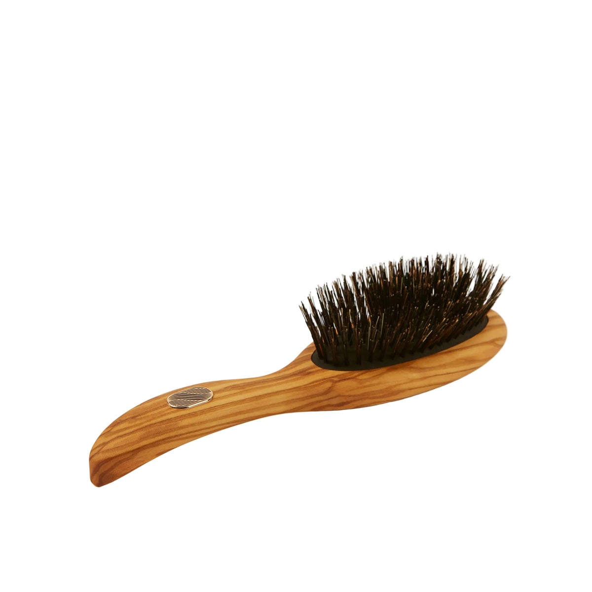 A wooden hairbrush with a curved olive wood handle and dark brown bristles, photographed on a clean, solid off-white background.