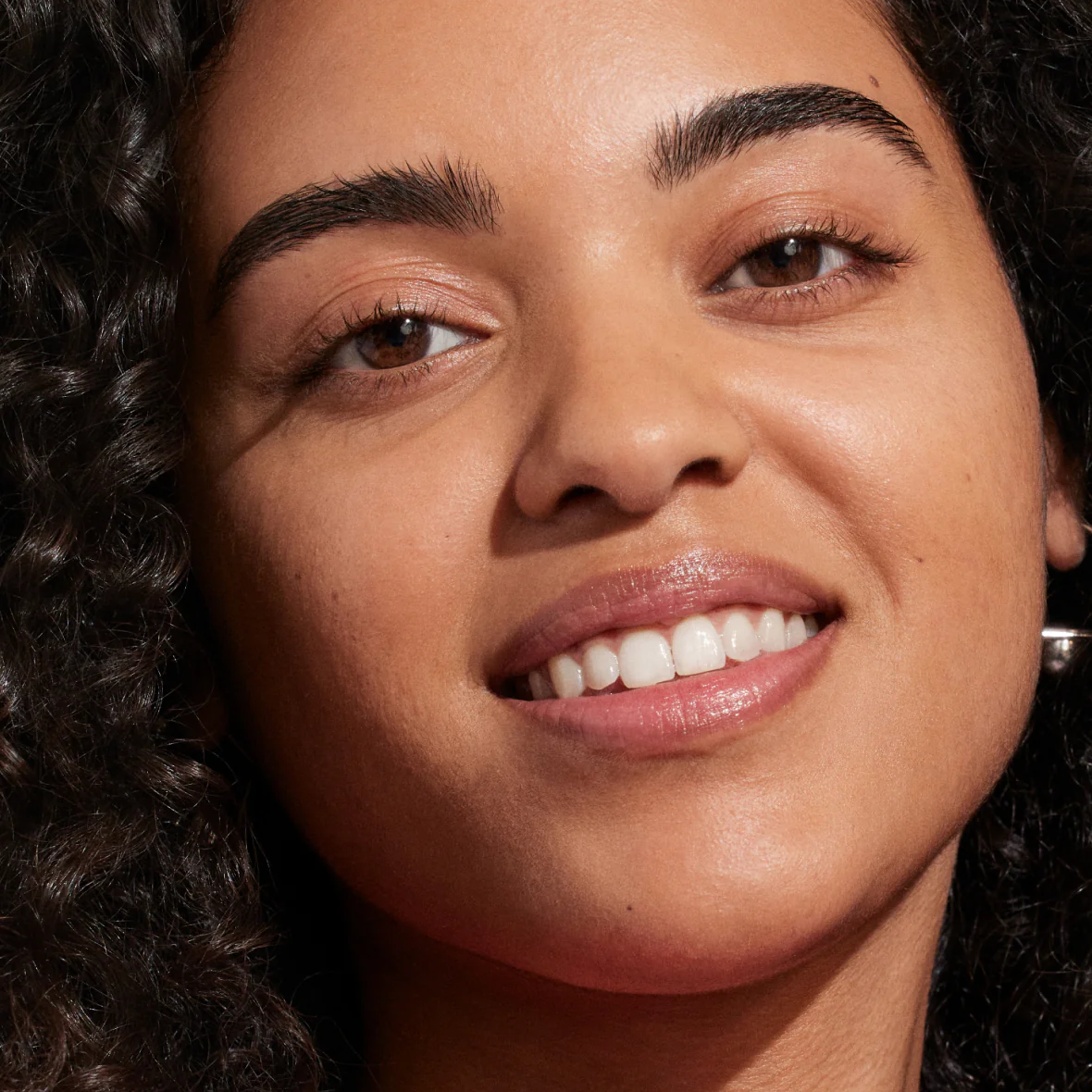 Closeup of a woman's face wearing Supergoop! ProtecTINT SPF makeup. 