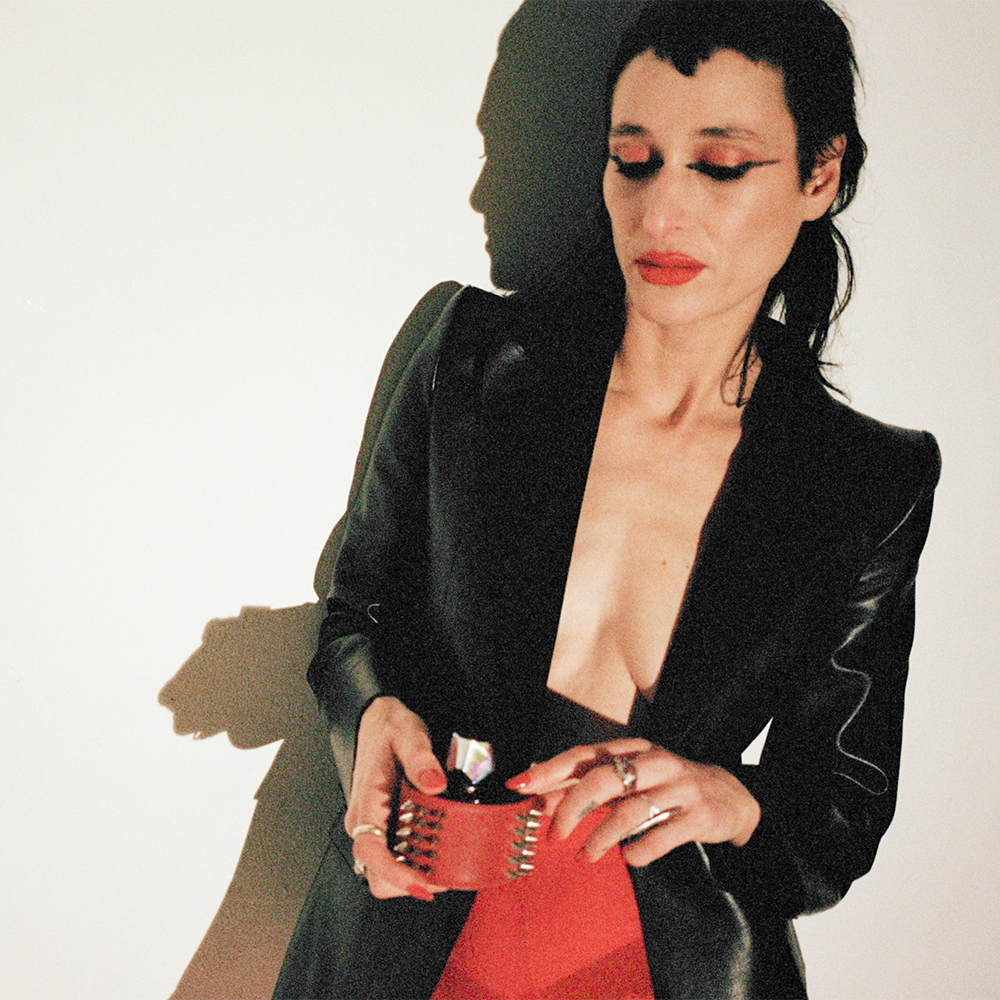 Woman in black and red on a white background with strong lighting
