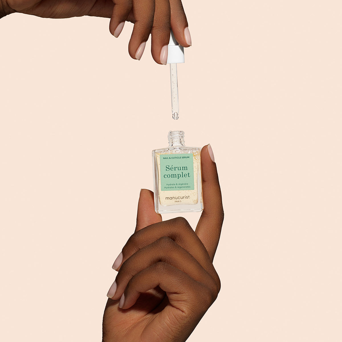 Hands holding Complete Serum on pink background 
