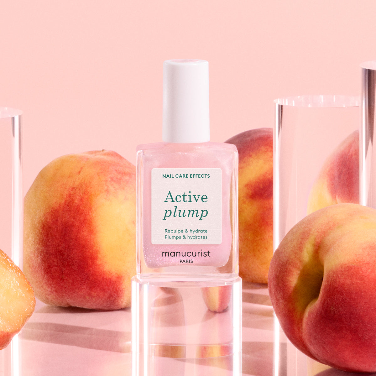 Manucurist Active Plump alongside peaches on pink background 