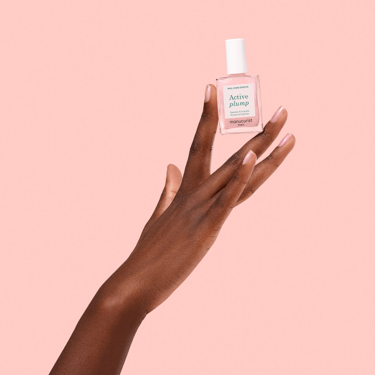Darker Shade Hand Wearing and holding Manucurist Active Plump 