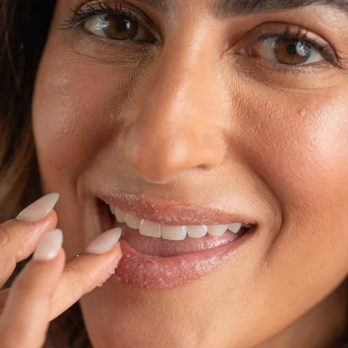 Close-up of a woman's face with a focus on her lips and hand.