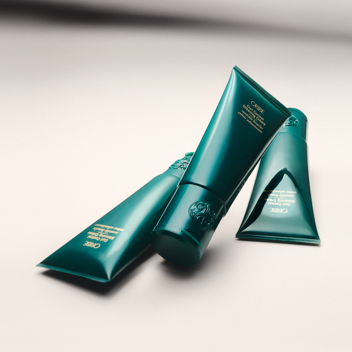 Three green haircare products on a light gray background