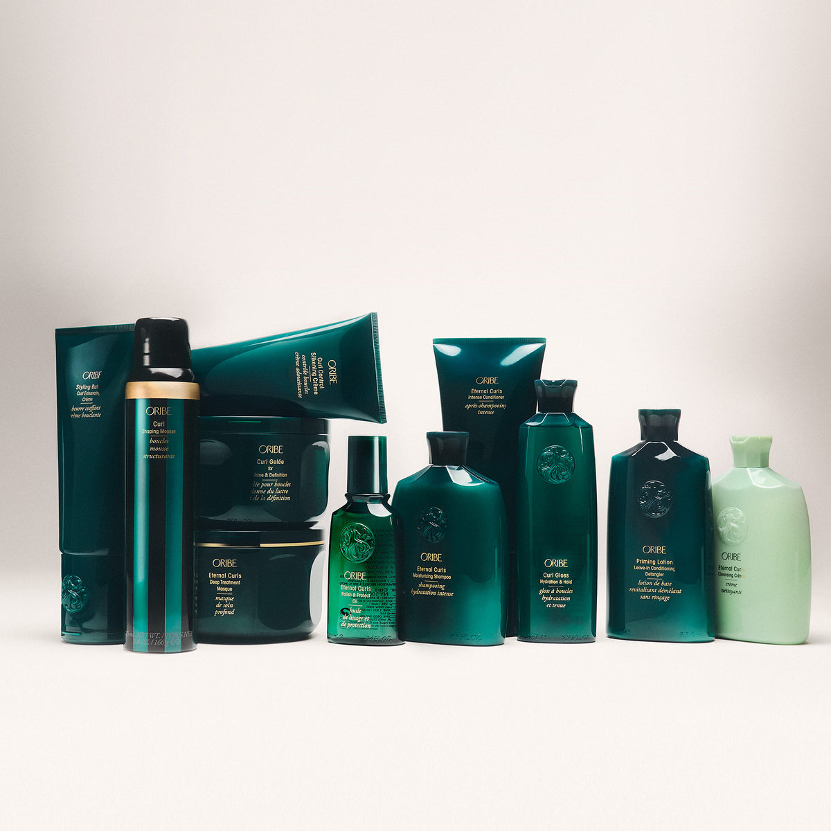 Collection of green haircare products on a light gray background