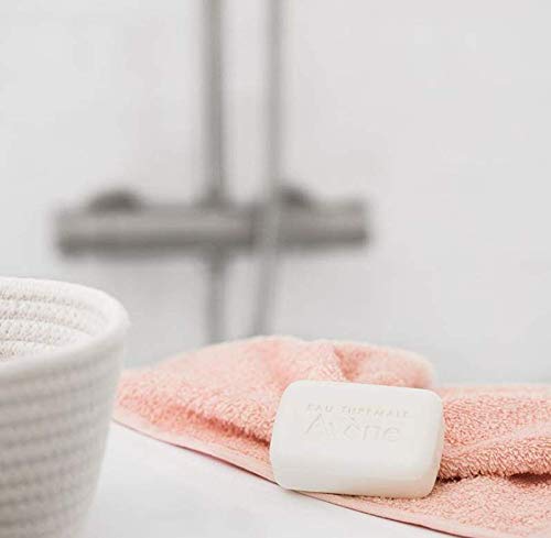 Avene Ultra Rich Cleansing Bar on a pink towel in a bathroom setting