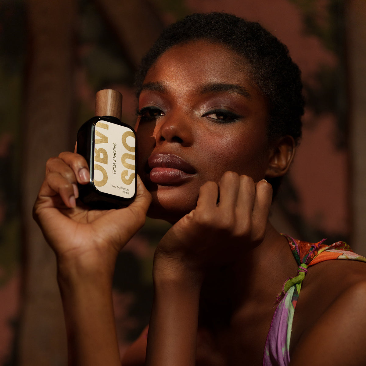 Woman holding a perfume bottle with a blurred background