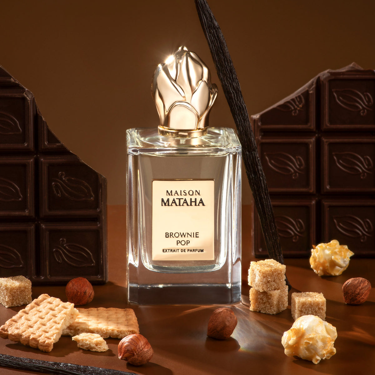 Maison Mataha perfume surrounded by chocolate, hazelnuts, and caramel corn