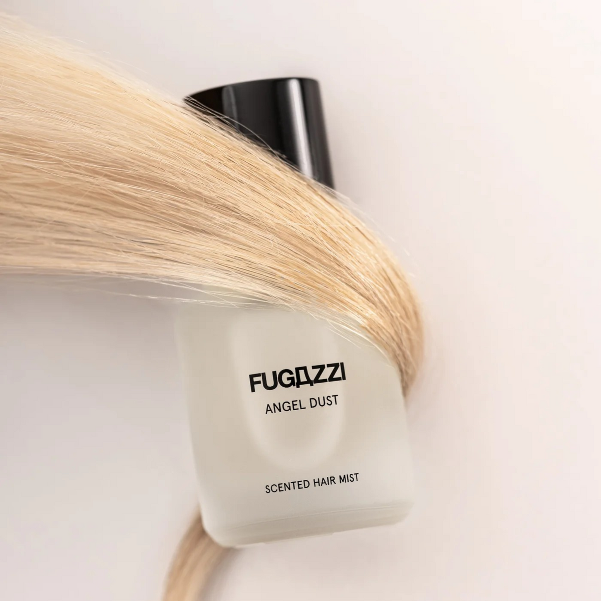 fugazzi scented hair mist bottle wrapped by blonde hair.