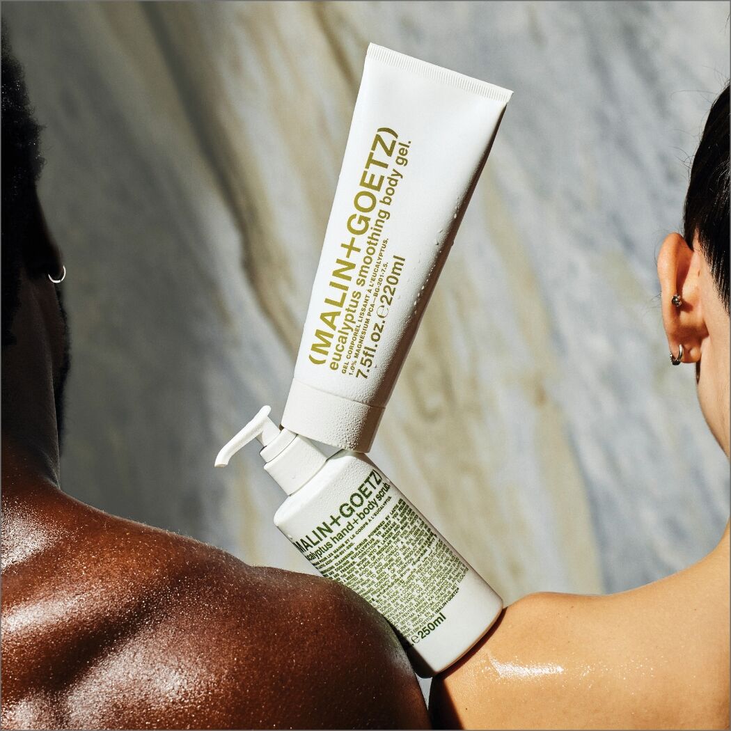 Malin + Goetz Eucalyptus Smoothing Body Gel and Eucalyptus Body Scrub along side two models 