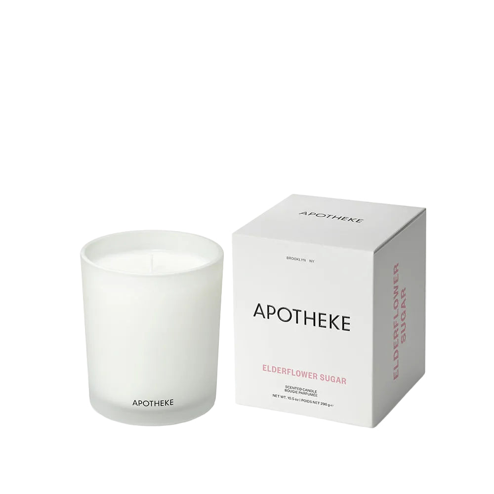 A frosted glass jar candle next to its white packaging box, both featuring the brand name 'APOTHEKE' and scent name 'Elderflower sugar ' on a clean white background.