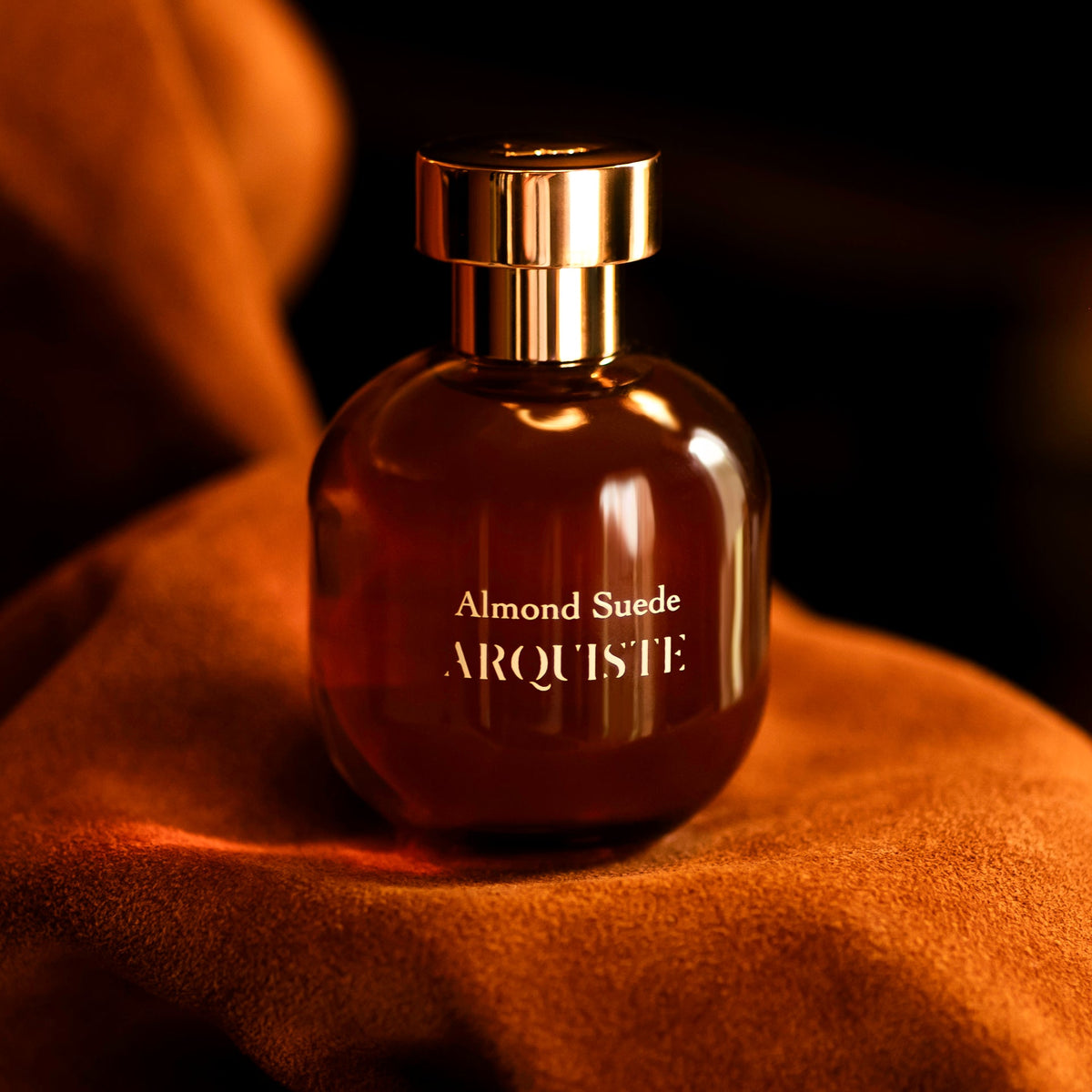 Almond Suede perfume bottle on orange suede
