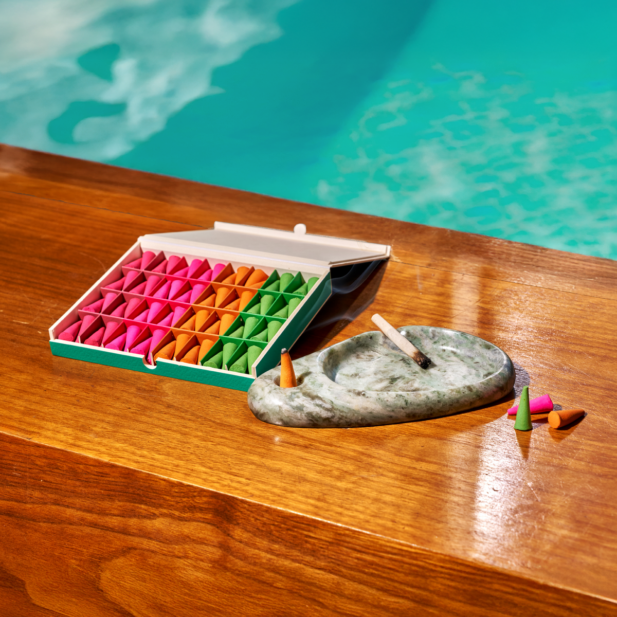 Houseplant By Ripple+ Ash & Scent Set ripple droplets and ashtray on a wood surface in front of blue water.
