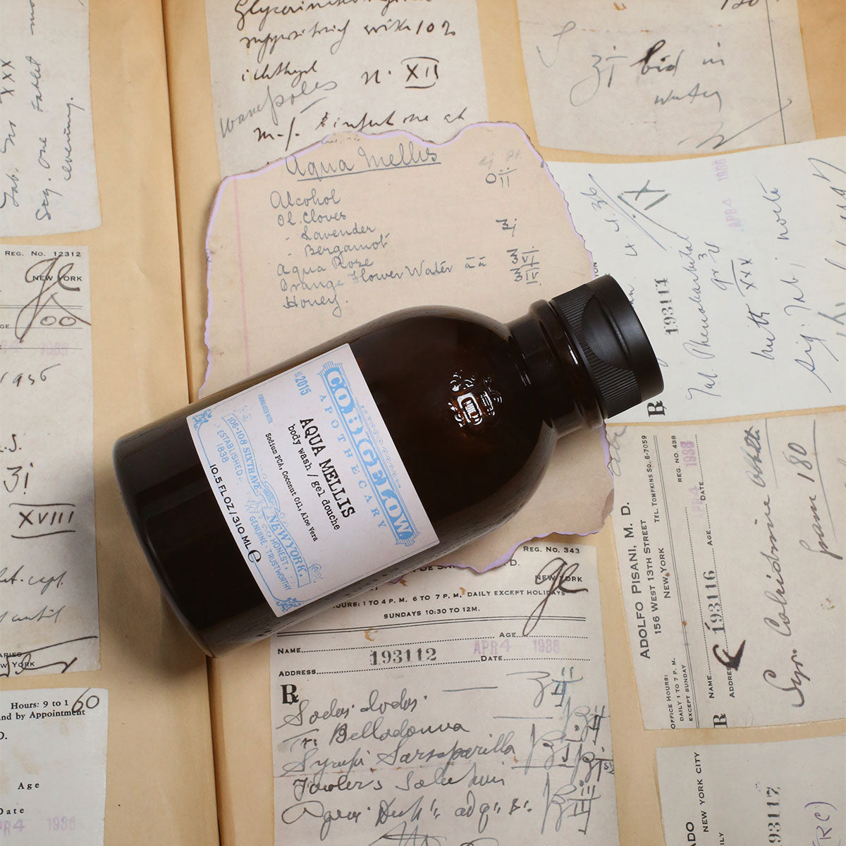 C.O. Bigelow Aqua Mellis Body Wash in an amber bottle on top of the original Aqua Mellis formulary and recipe book. 