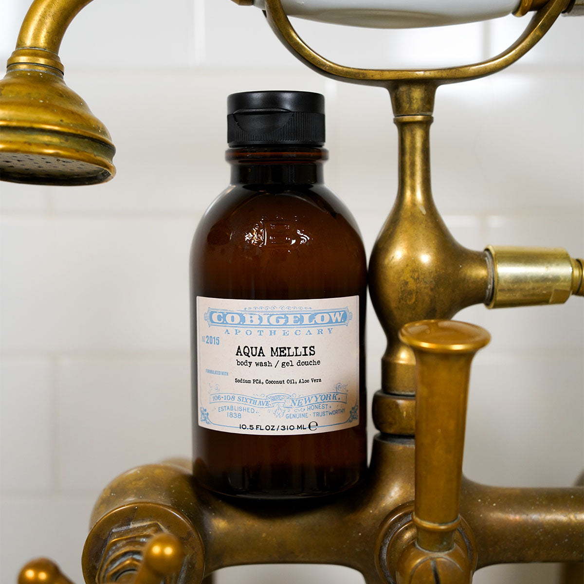 C.O. Bigelow Iconic Collection Aqua Mellis Body Wash sitting on a brass shower spout. 