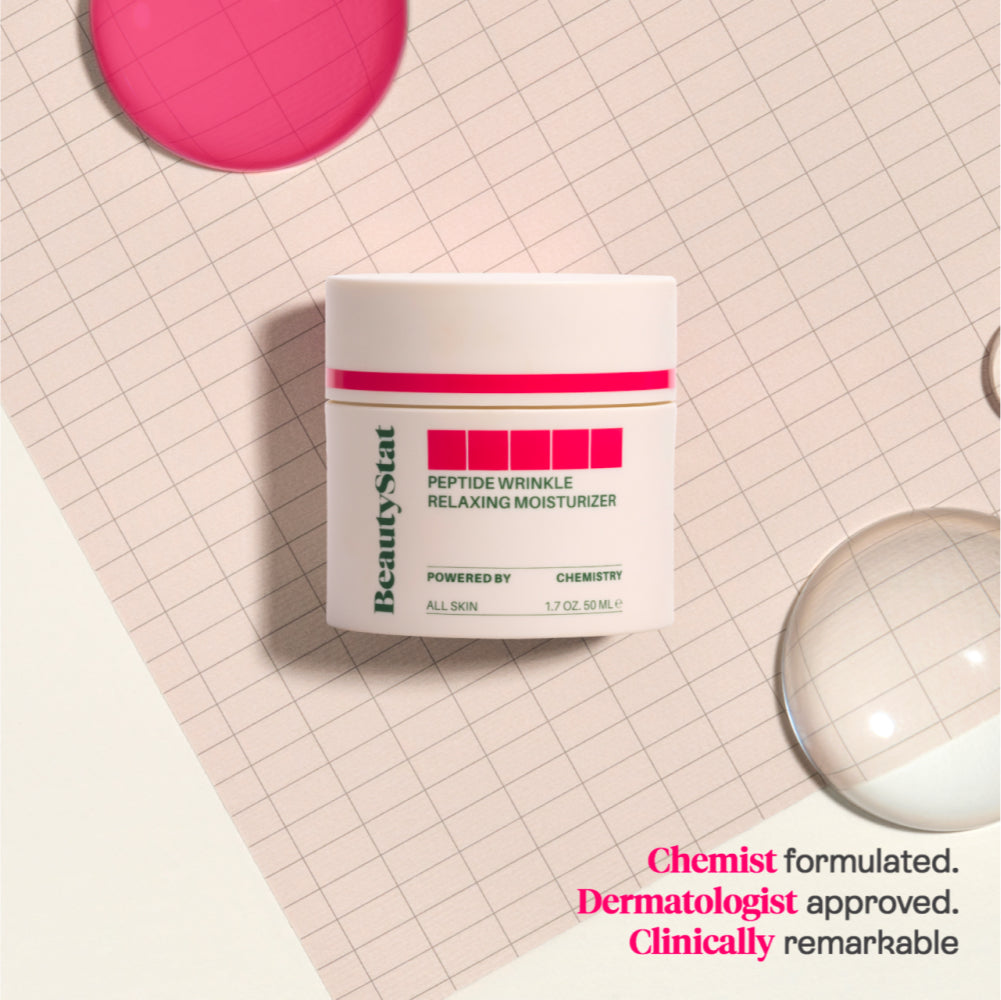 Tub of Peptide Wrinkle Relaxing Moisturizer by BeautyStat on a gridded background next to droplets of liquid