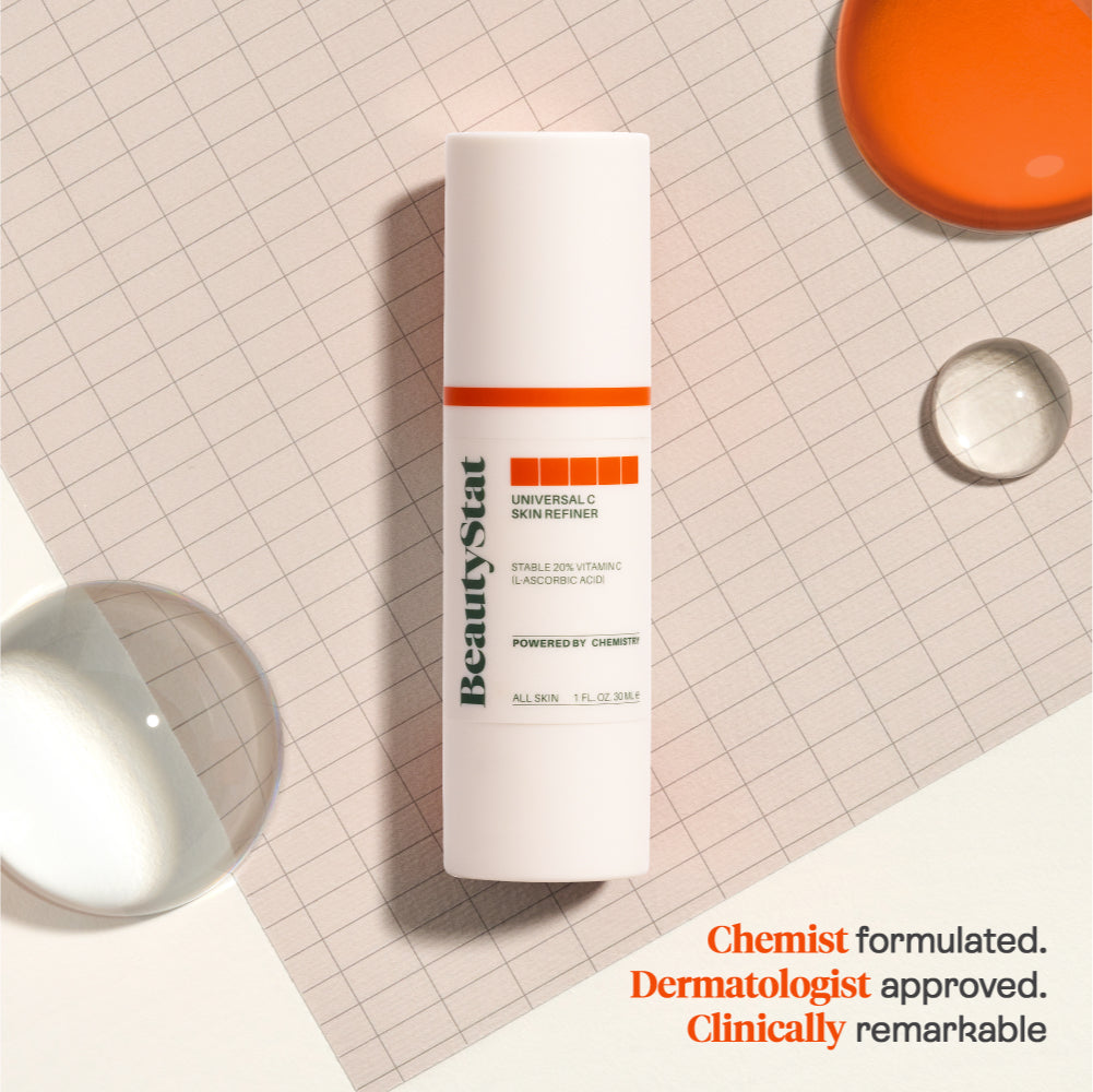 Universal C Skin Refiner by BeautyStat on a gridded background with large droplets of liquid