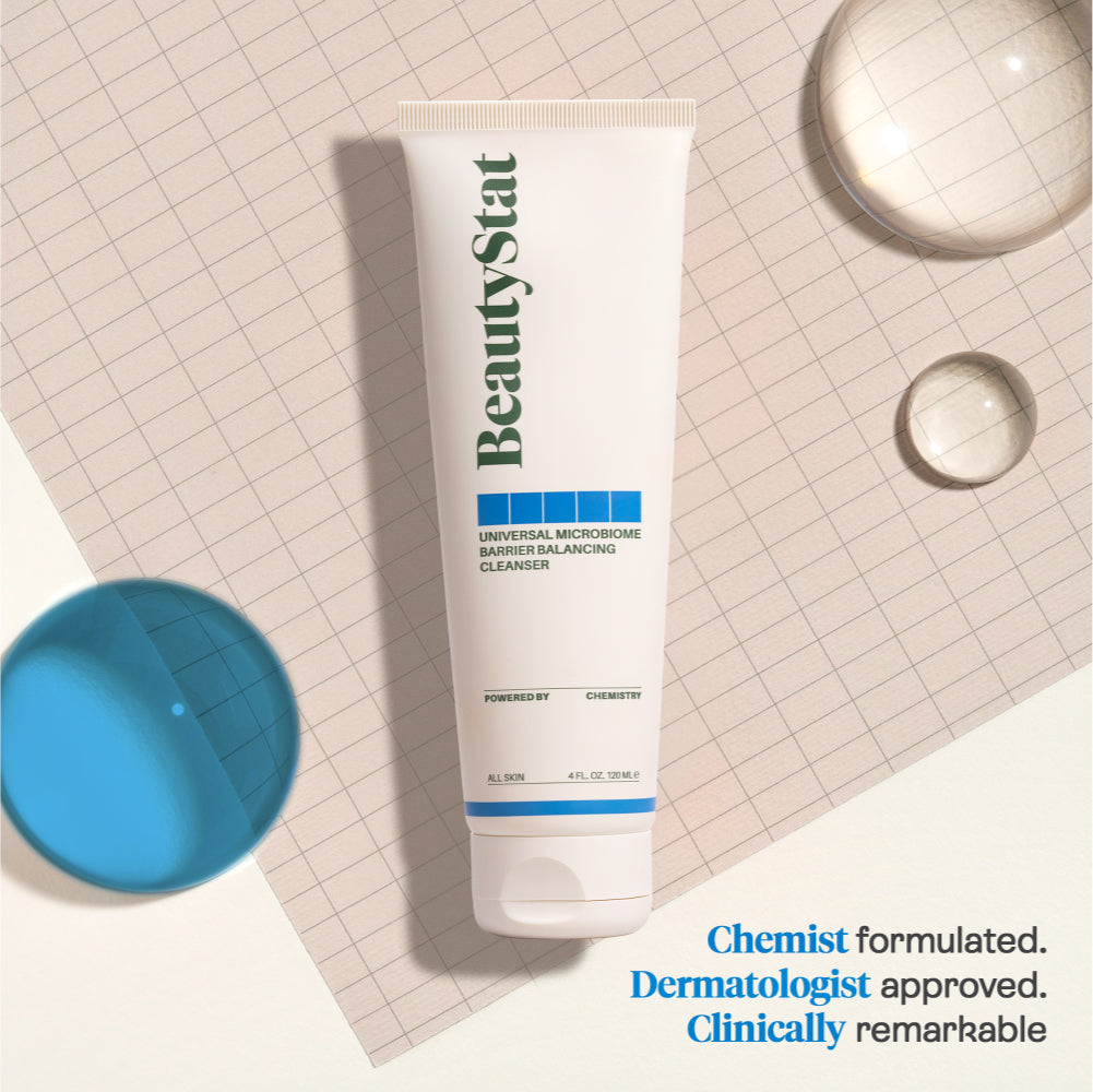 A tube of BeautyStat Microbiome Barrier Repair Purifying Cleanser on a gridded background next to large drops of liquid
