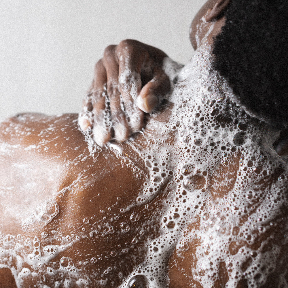 Man washing soapy back with Bravo Sierra body wash.