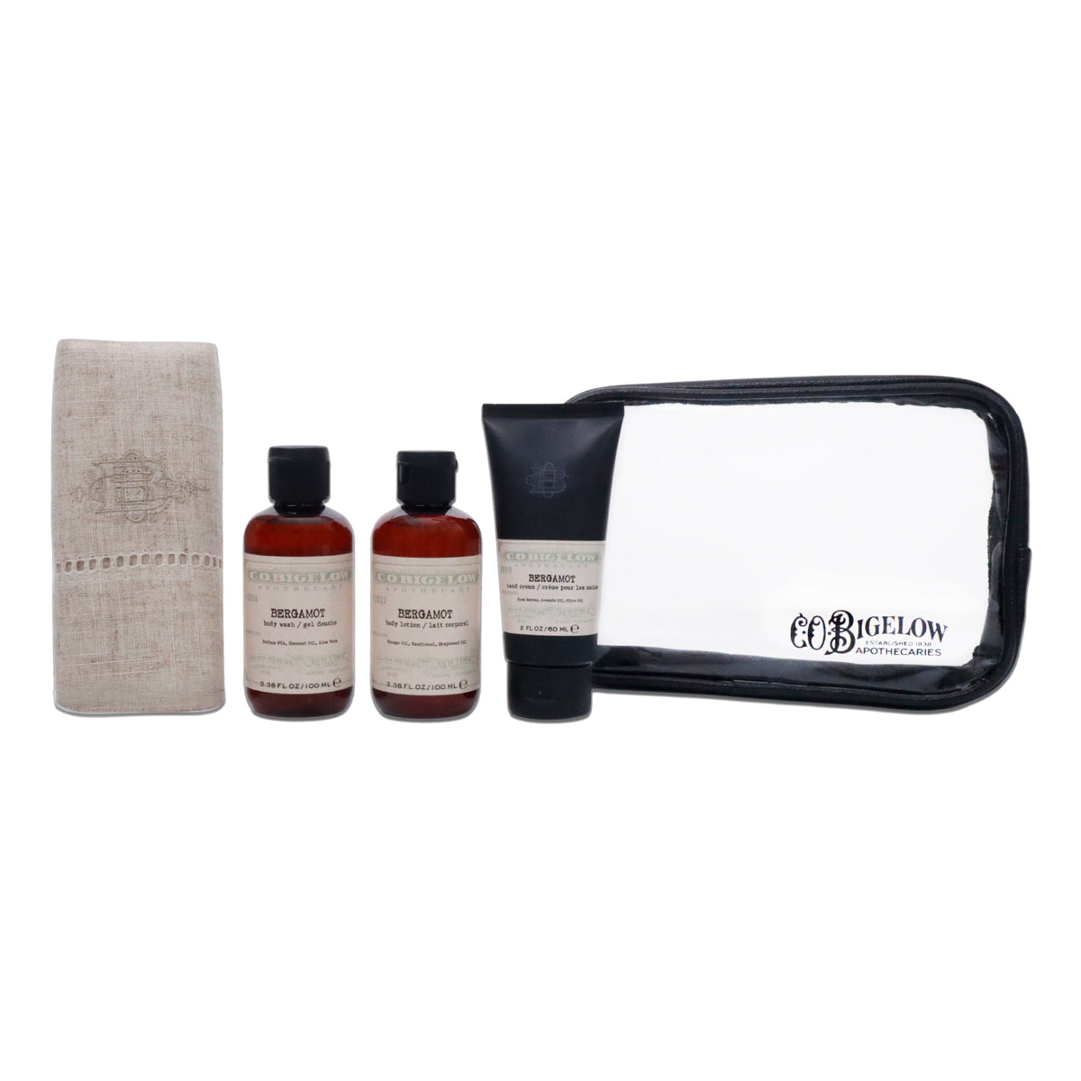 A toiletry gift set featuring two amber bottles, a black tube, a beige towel, and a clear zippered pouch with black trim.