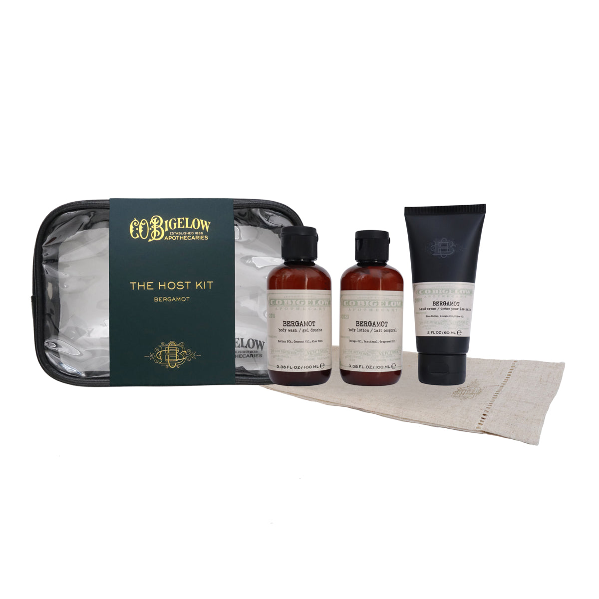 Bigelow Apothecary 'The Host Kit' for Bergamot, featuring a black zippered case with a dark green label, two amber glass bottles, a black squeeze tube, and a beige linen towel on a white background.