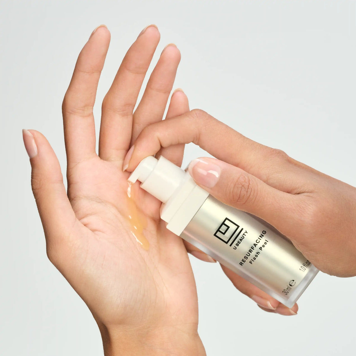 Hand holding a skincare product with visible brand on a neutral background