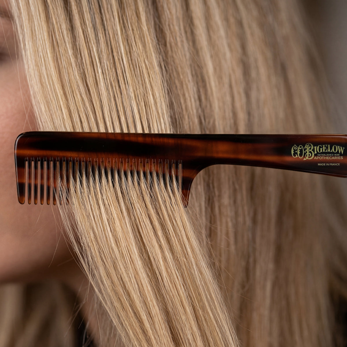 Bigelow Handle Acetate Comb brushing blonde hair.