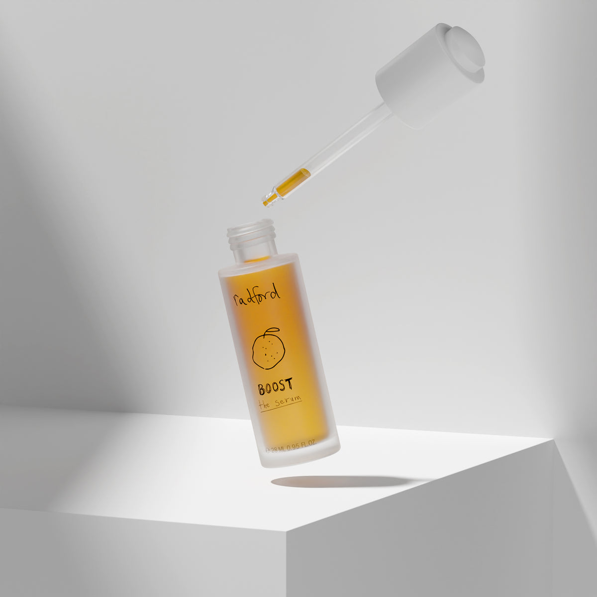 Radford BOOST-the serum with amber-yellow liquid inside, shown floating above a white geometric pedestal with the applicator dropper hovering above the open bottle against a light gray studio background.