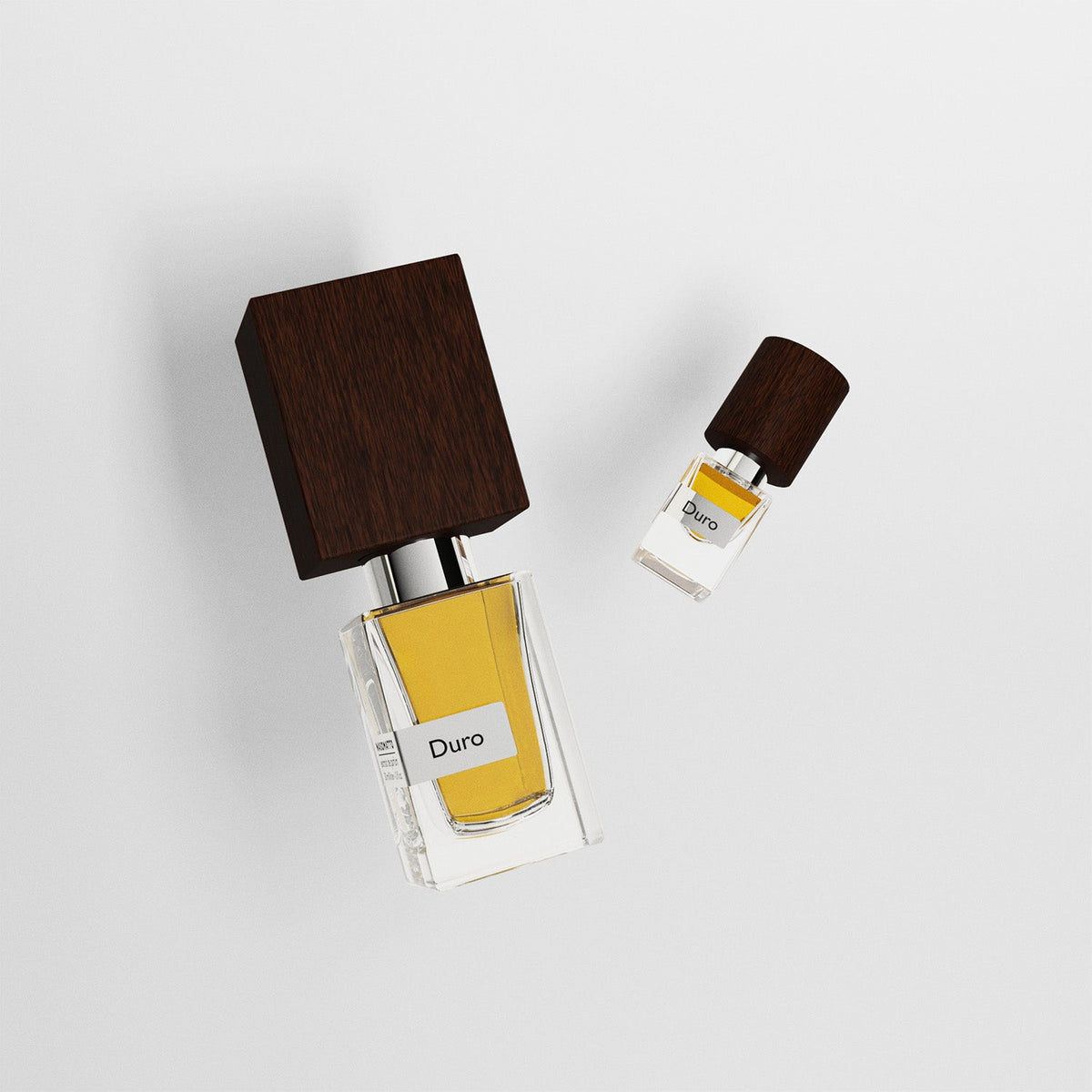 Two perfume bottles with wooden caps on a light gray background