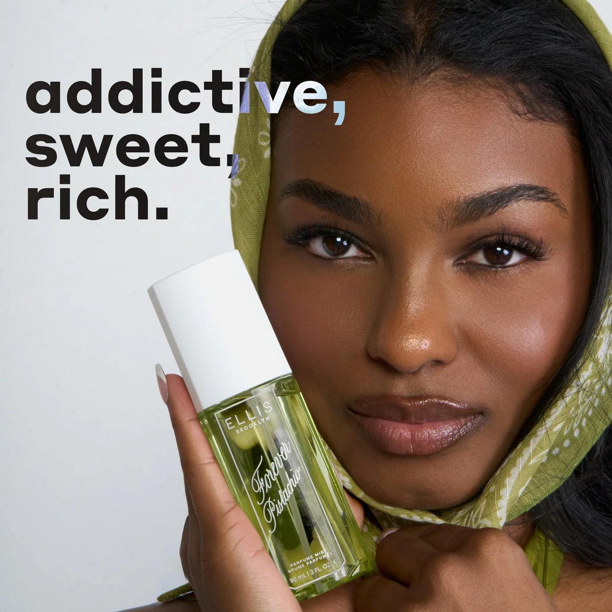 Woman holding a green bottle with text 'addictive, sweet, rich.'
