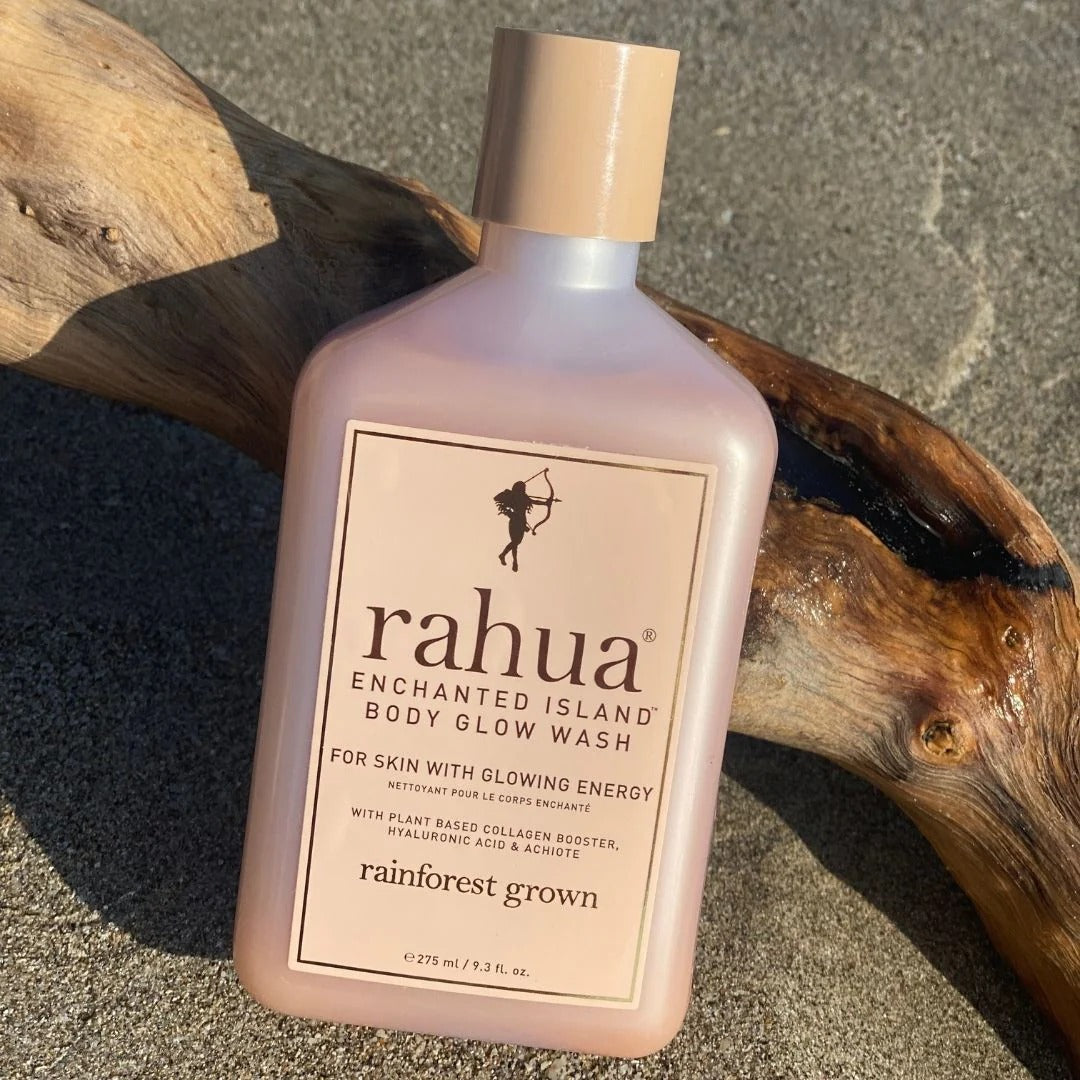 Rahua Enchanted Island Glow Body Wash on a branch on sand.