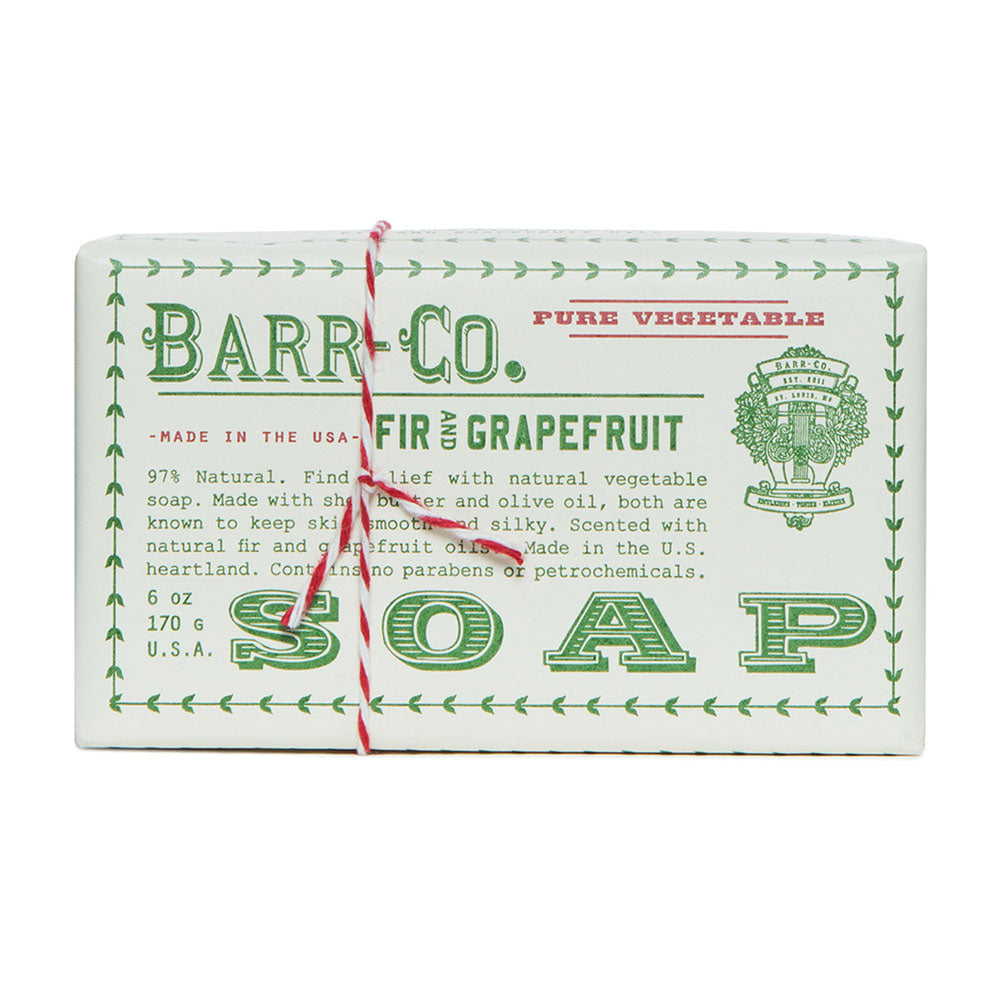 A bar of soap with 'Barr-Co. Pure Vegetable' text is made with natural ingredients such as fir and grapefruit.