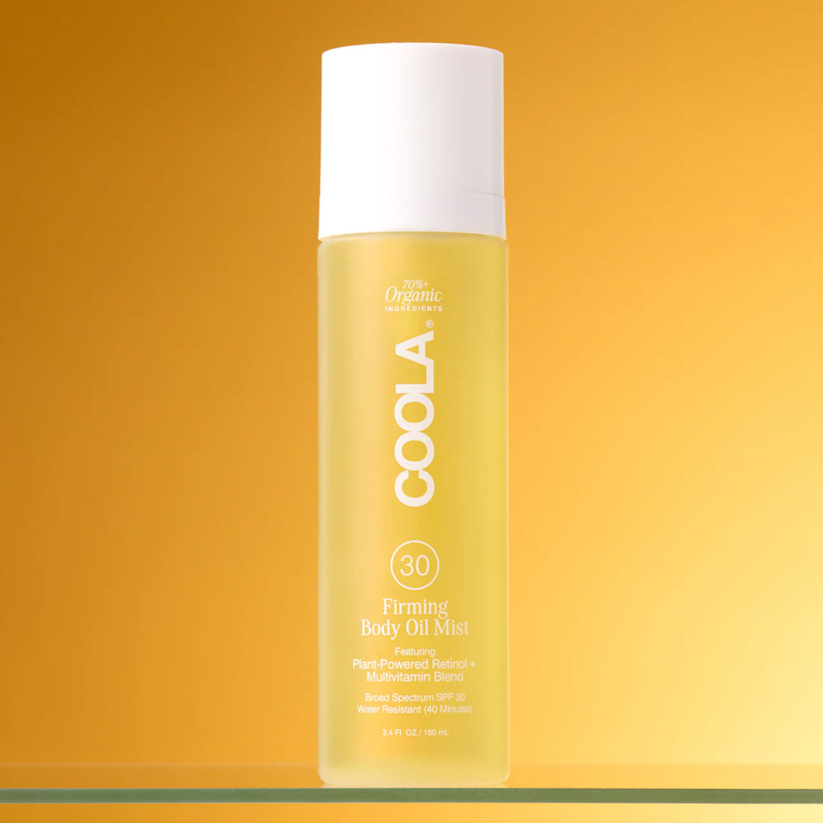 COOLA Firming Body Oil Mist product on a yellow background