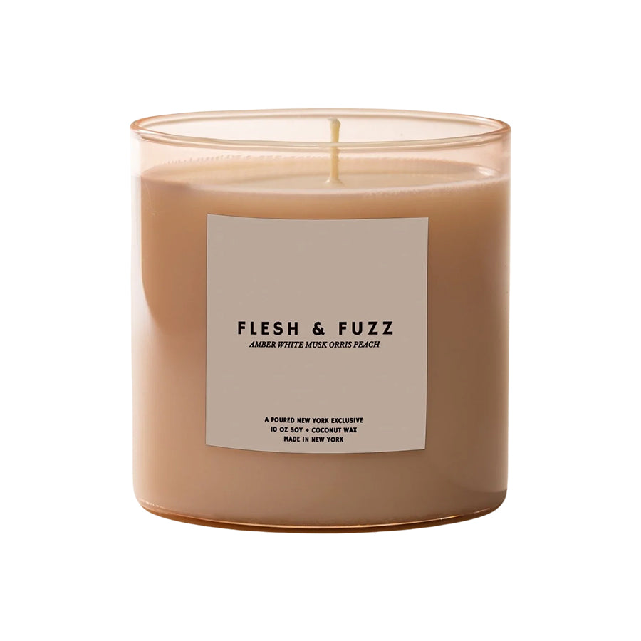 Candle with a label titled 'Flesh & Fuzz' on a white background