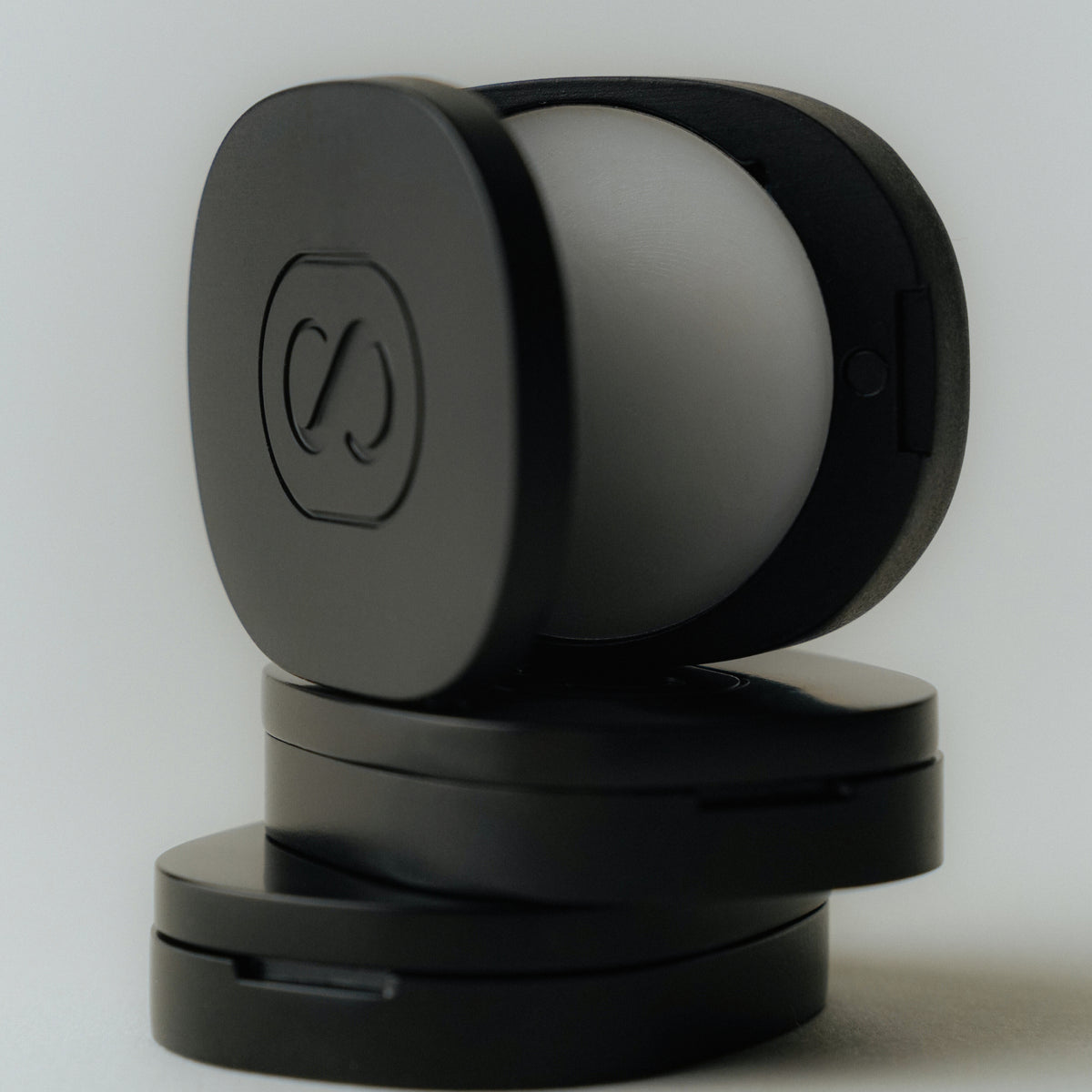 Stack of The Solid Perfume "Braless" in a black case on a white background